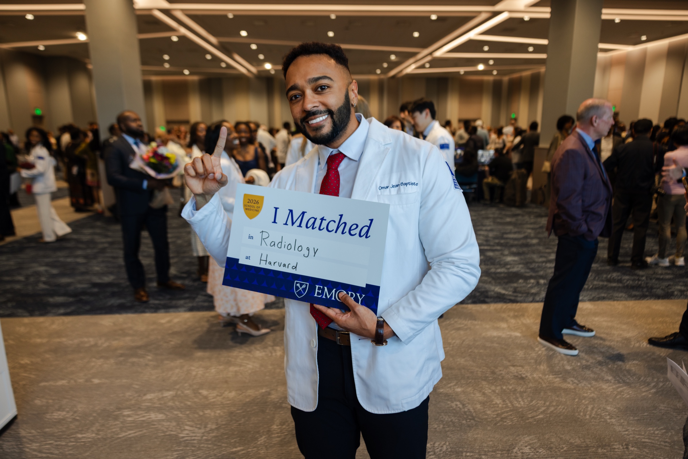 Omar Jean-Baptiste holding an I Matched sign on Match Day.